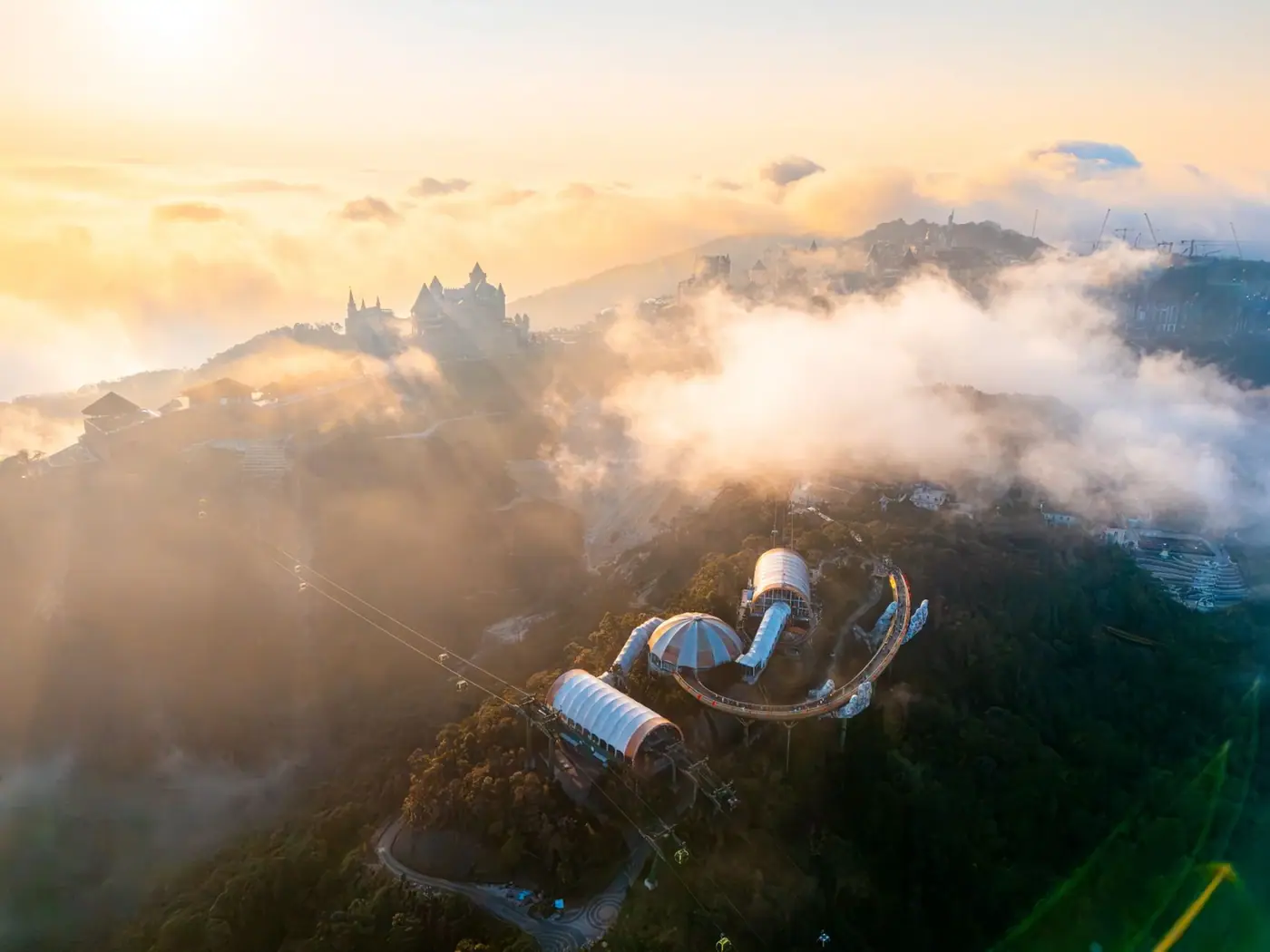 Aerial view of Ba Na Hills cable car stations above the clouds at sunrise