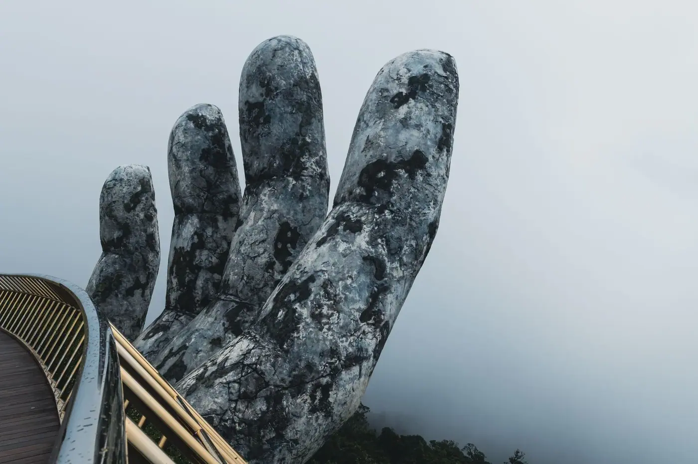 Close-up of the Golden Bridge giant hand sculpture in fog