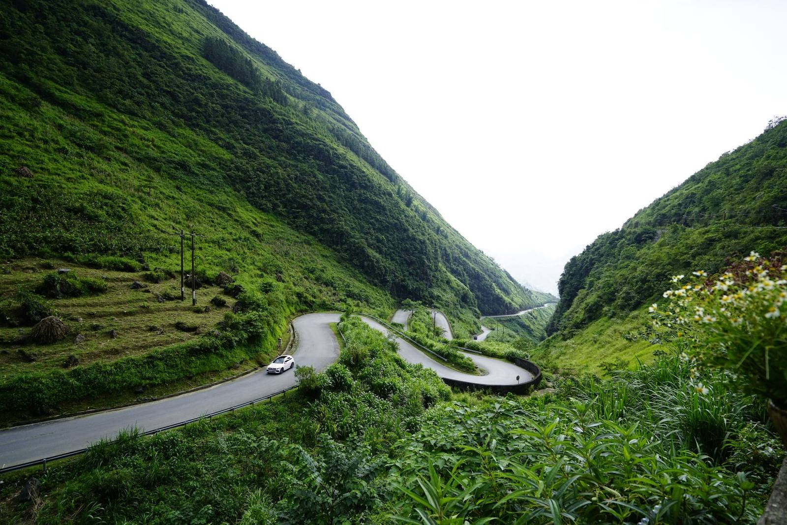 A winding mountain road through green hills in Vietnam
