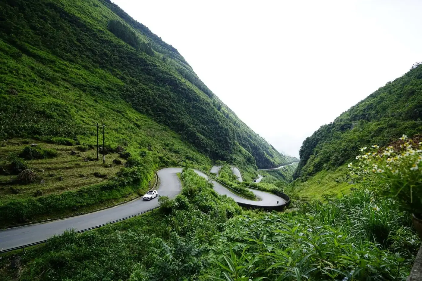 A winding mountain road through green hills in Vietnam