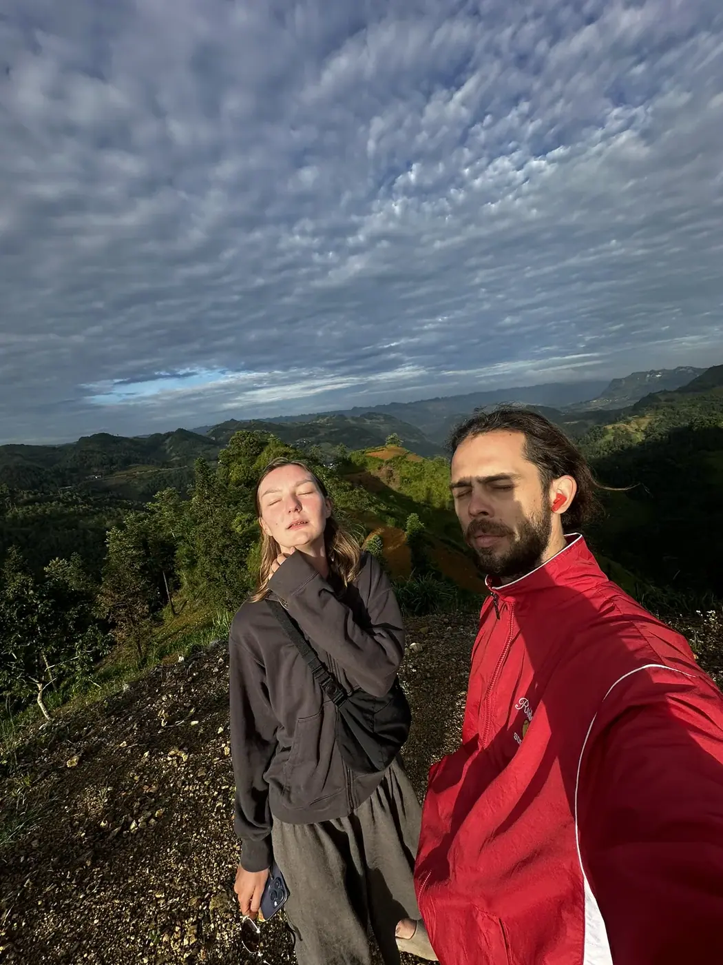 Couple standing on a mountain overlook above the Ha Giang Loop karst hills