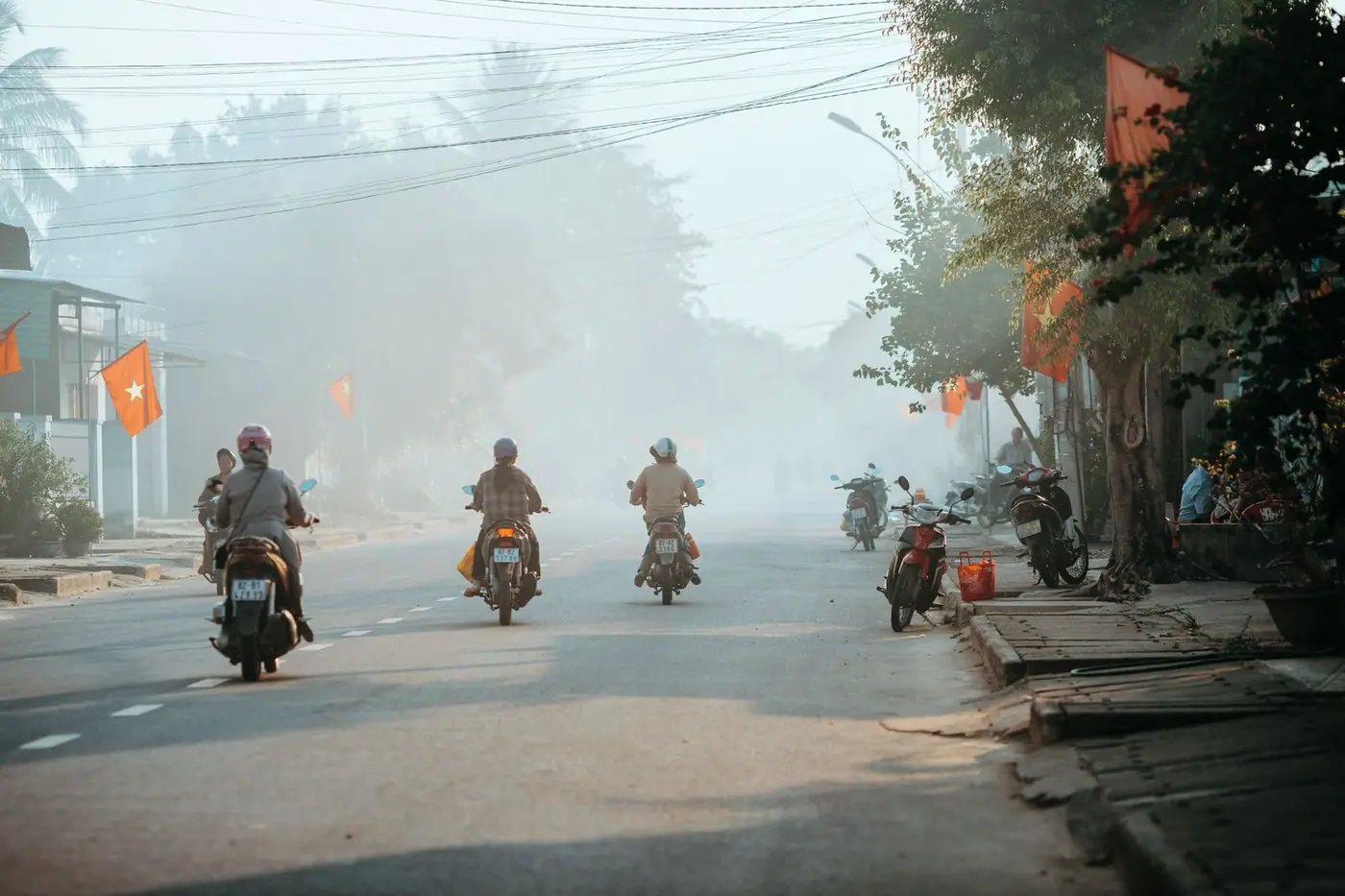 Motorbike riders on a misty rural road in Kon Tum, Vietnam