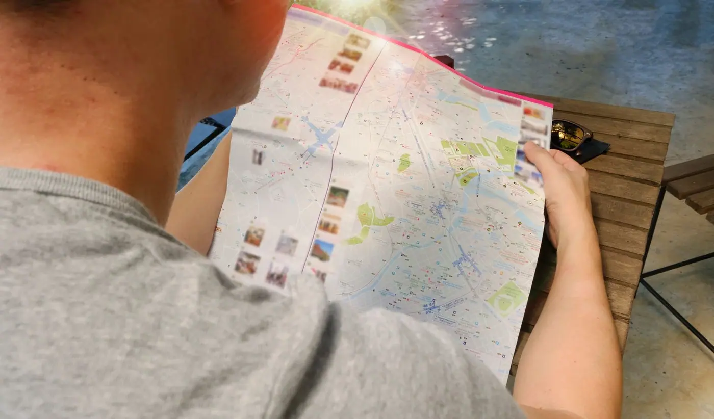 Traveler studying a paper map to plan a multi-region route