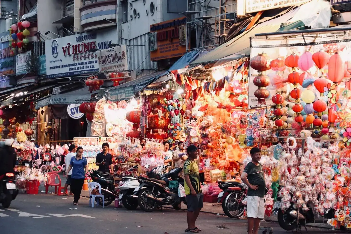 A busy night market street lined with colorful lanterns and stalls