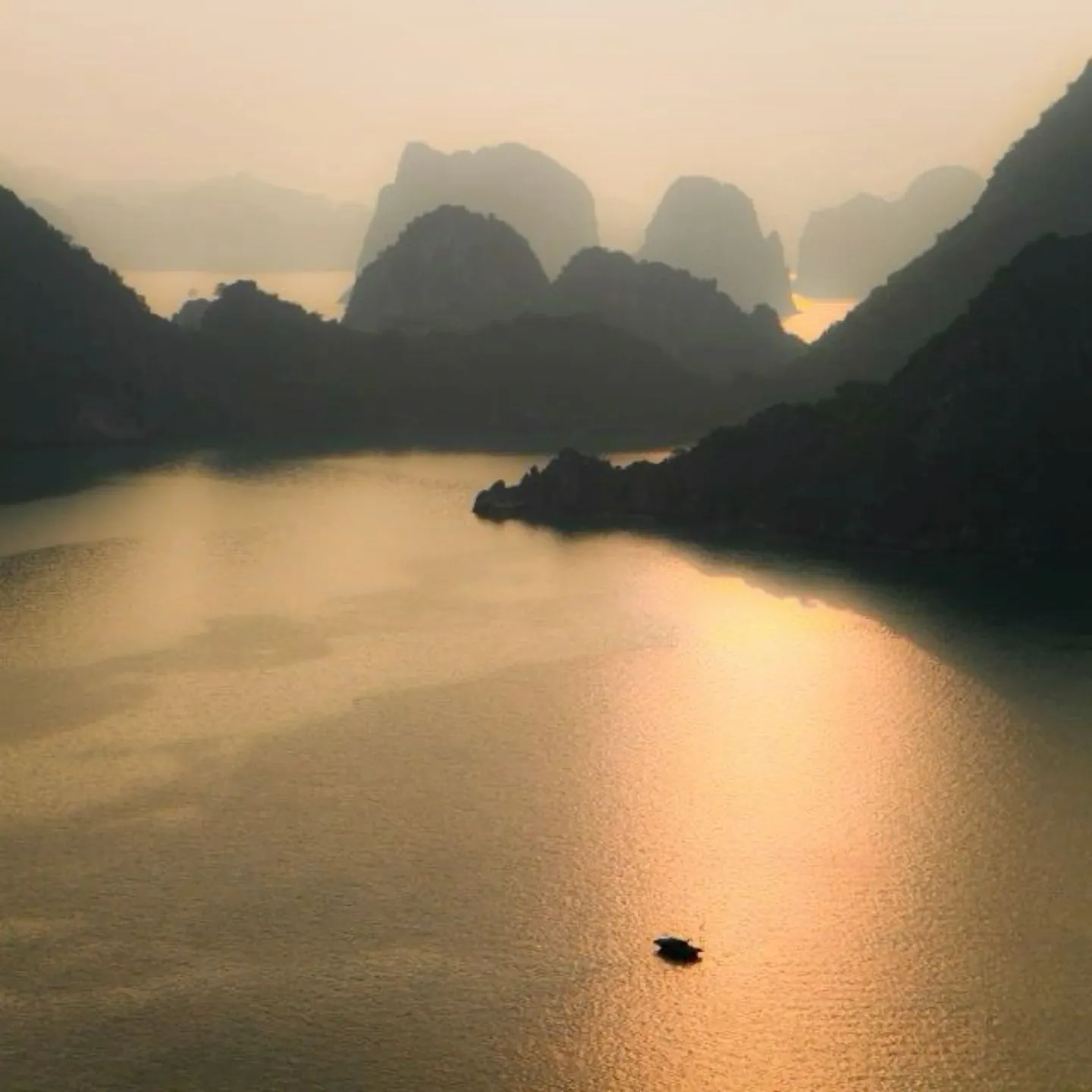 a small boat floating on top of a large body of water surrounded by mountains in the distance