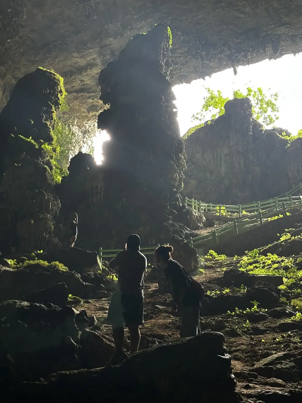 Travelers silhouetted at the glowing mouth of a cave in central Vietnam