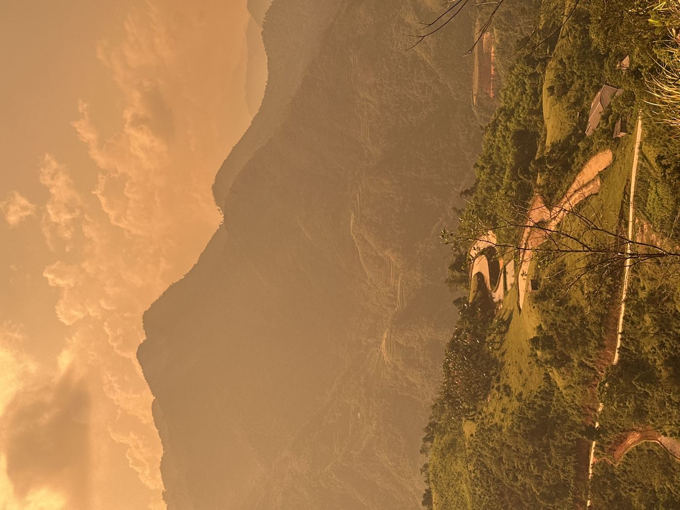 Winding mountain road in Vietnam at golden hour, layers of green ridges in the distance
