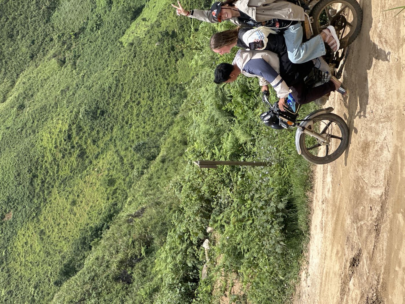 Group of riders at a mountain viewpoint in Vietnam with karst valley stretching behind them