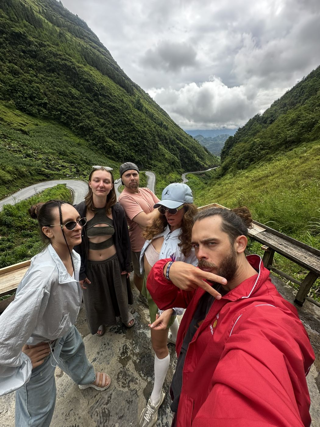 Riders at a mountain viewpoint in Vietnam overlooking a wide karst valley