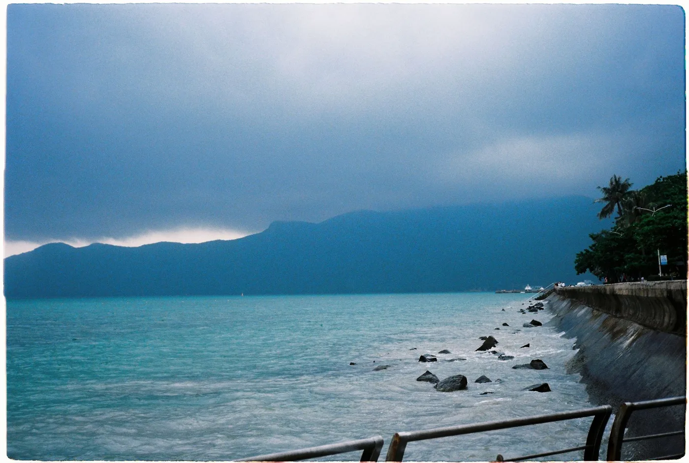 Storm clouds darkening over a quiet Vietnam coastal inlet at dusk
