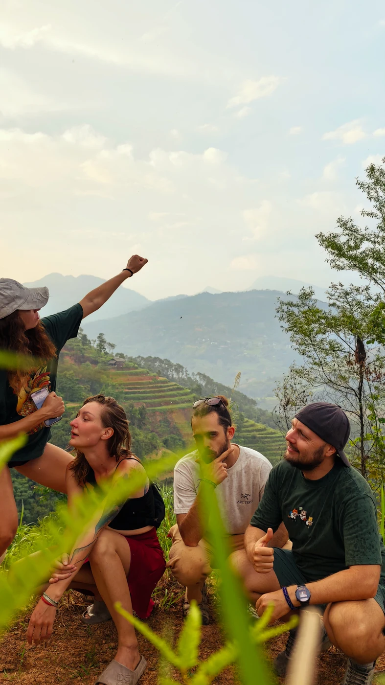 Small group of travelers relaxing together on a green hillside