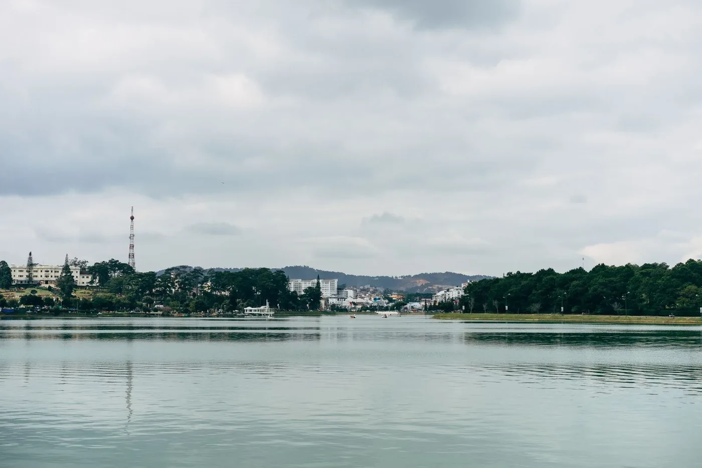 Xuan Huong Lake in Da Lat under a cloudy sky with the city skyline on the far shore