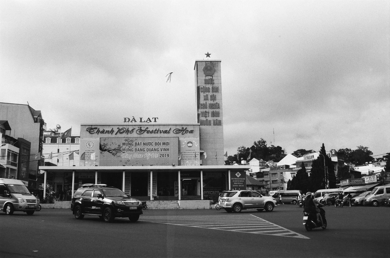 Black and white street scene in central Da Lat with the city hall clock tower