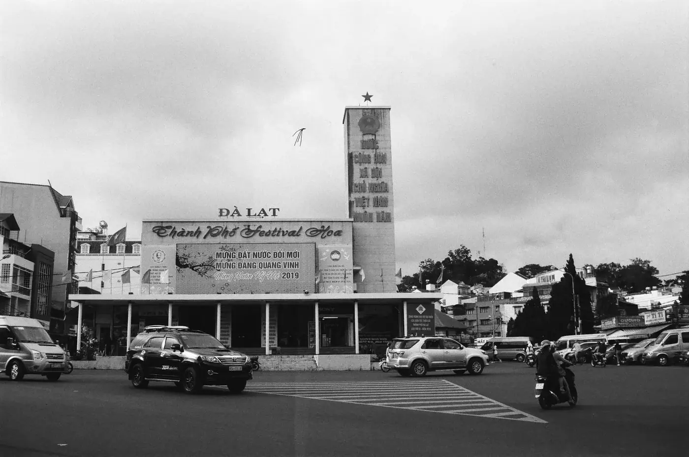 Black and white street scene in central Da Lat with the city hall clock tower