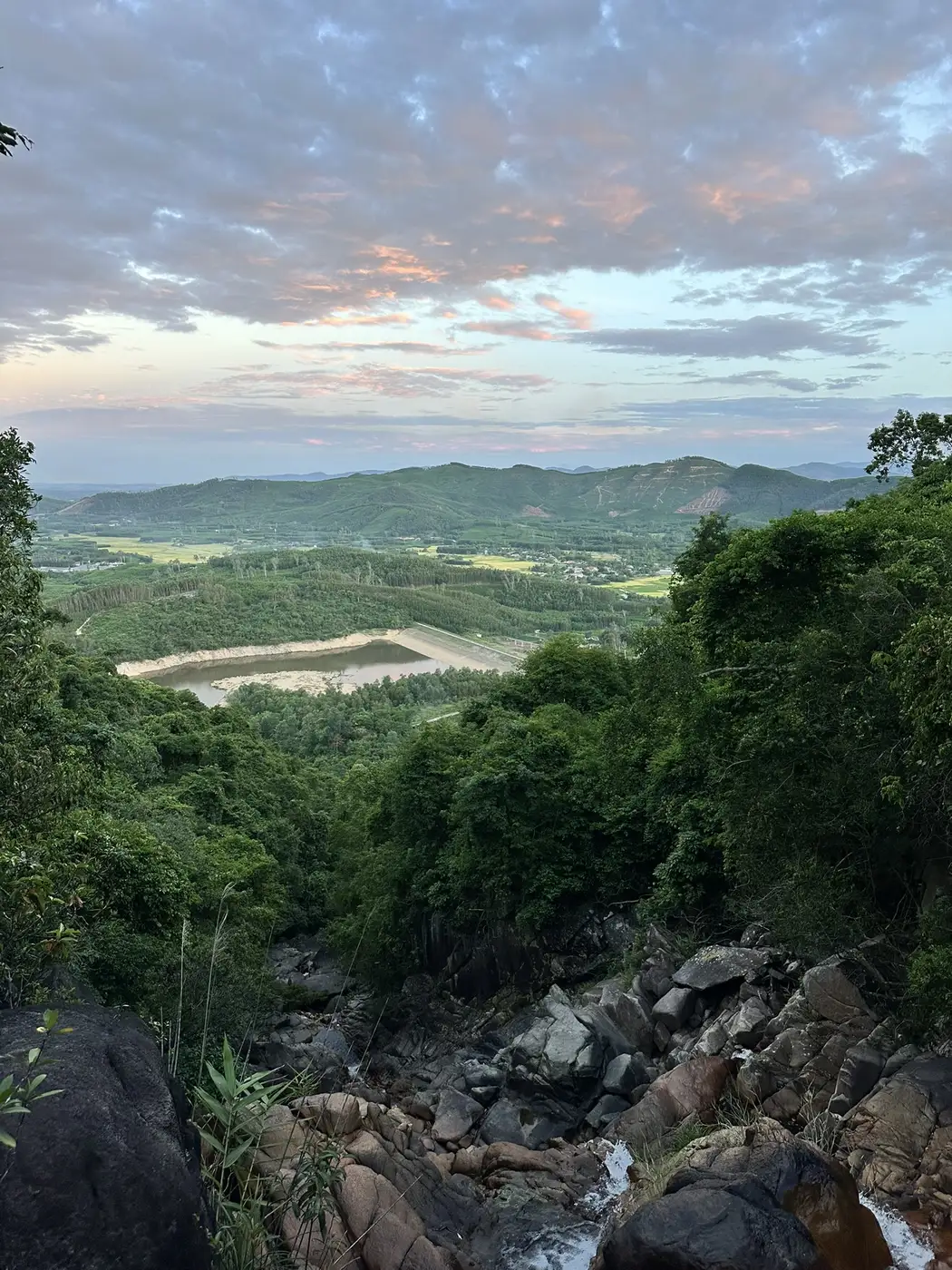 View from a hill over a reservoir and mountains around Hoi An at sunset