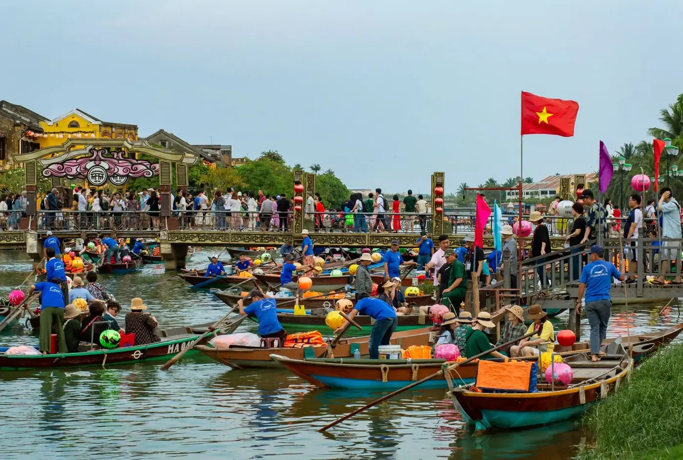 Tourist boats decorated with lanterns crowd the river in Hoi An Ancient Town