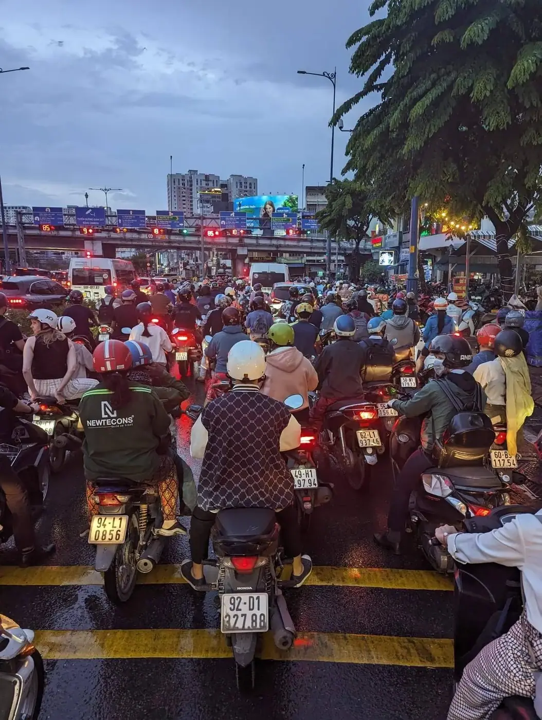 Dense motorbike traffic at a Ho Chi Minh City intersection at dusk