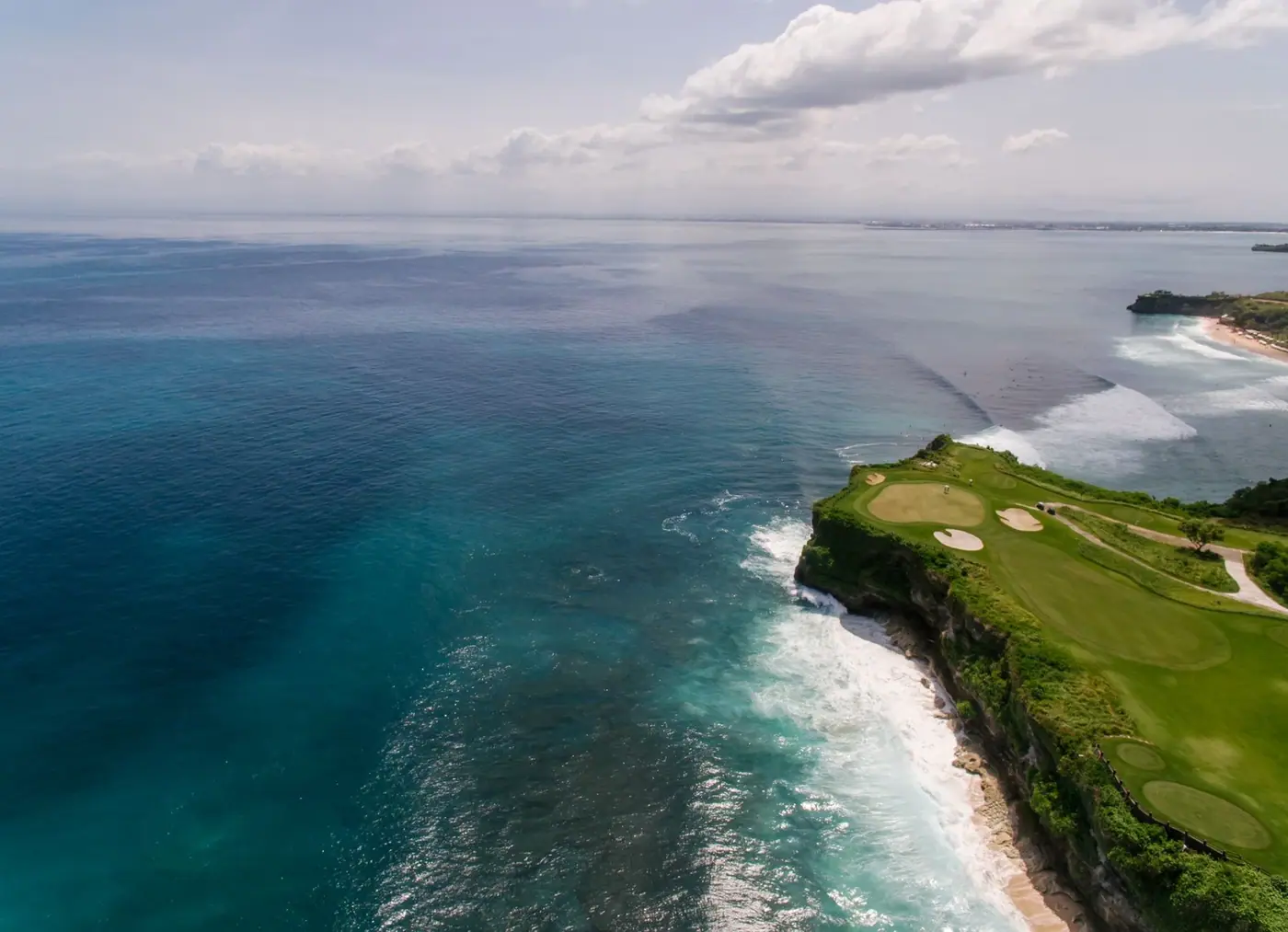 Aerial view of a links-style golf course along a rocky coastline