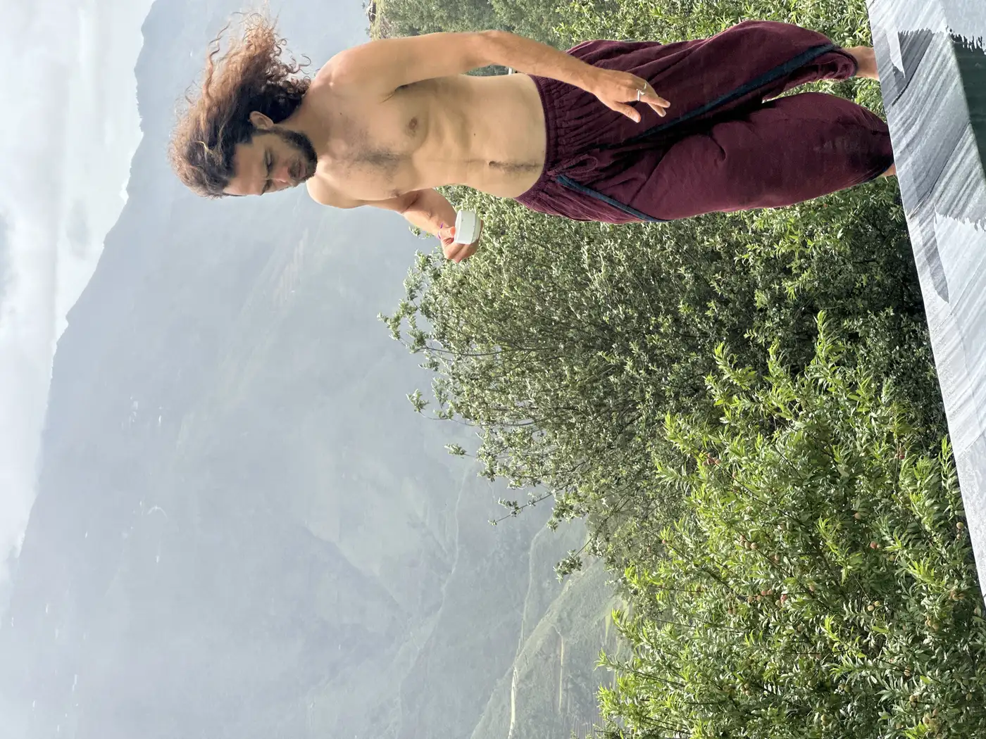 Traveler walking a terrace trail above foggy mountains near Sapa