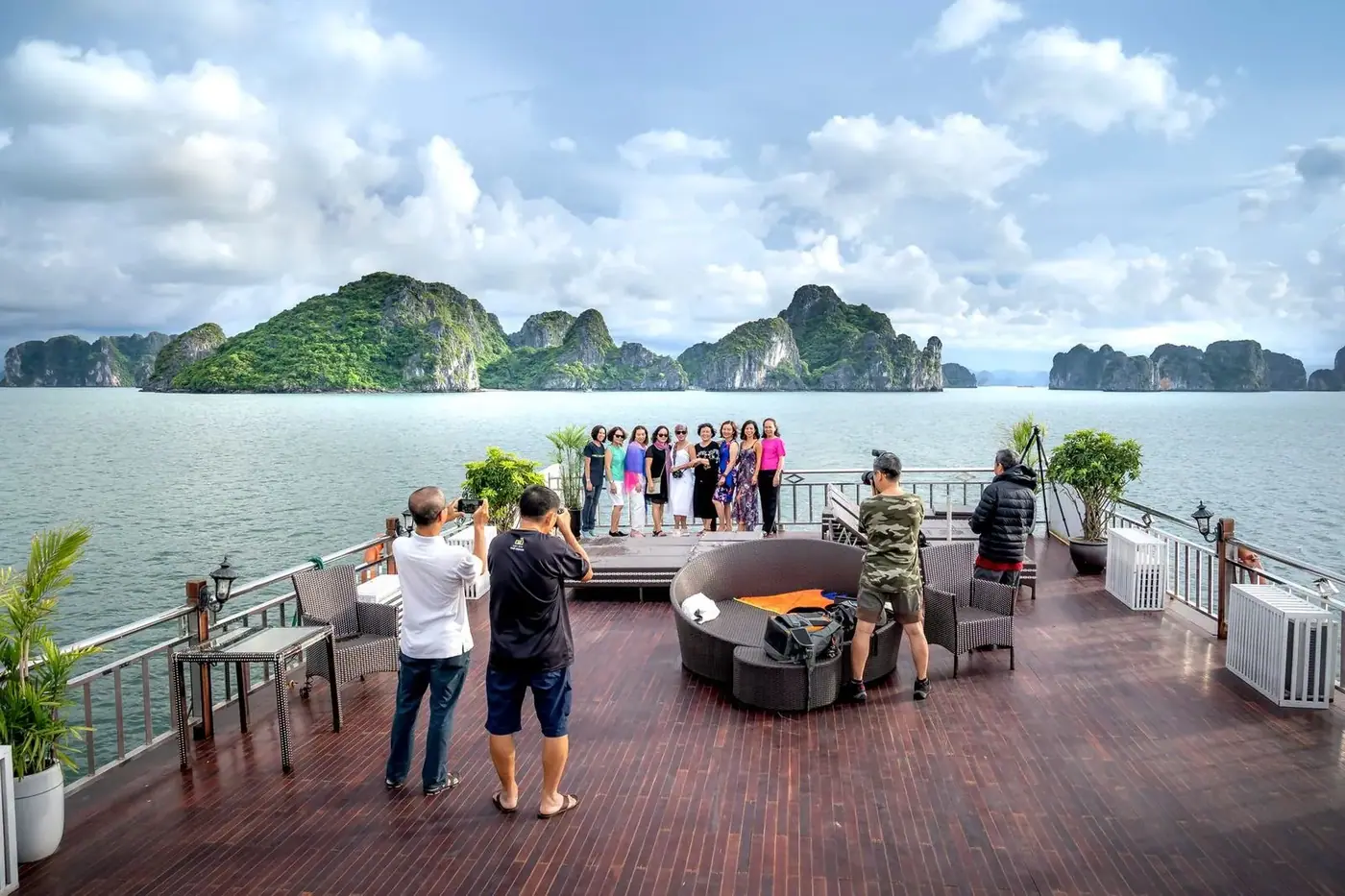 Passengers on a spacious upper deck overlooking Ha Long Bay islands