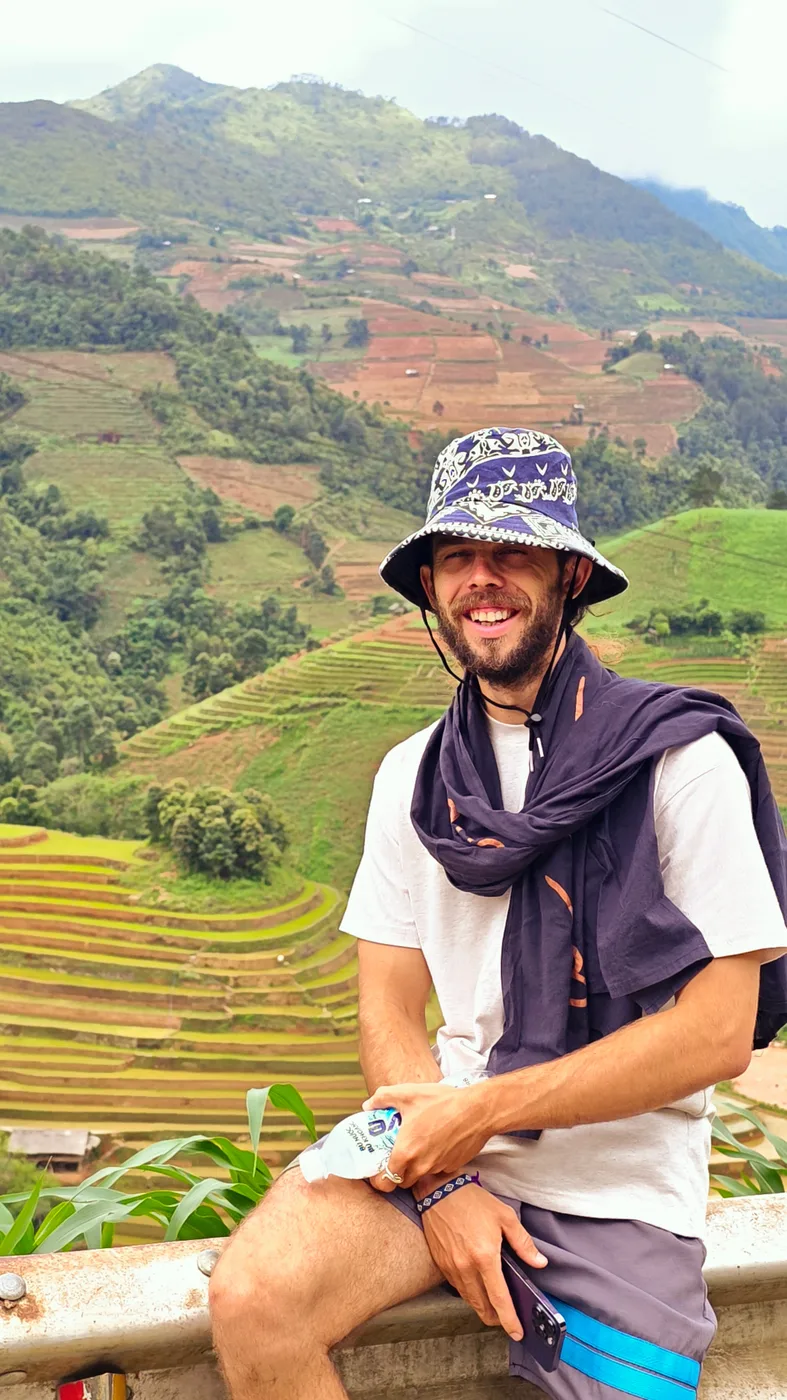 Man standing on a viewpoint above layered rice terraces