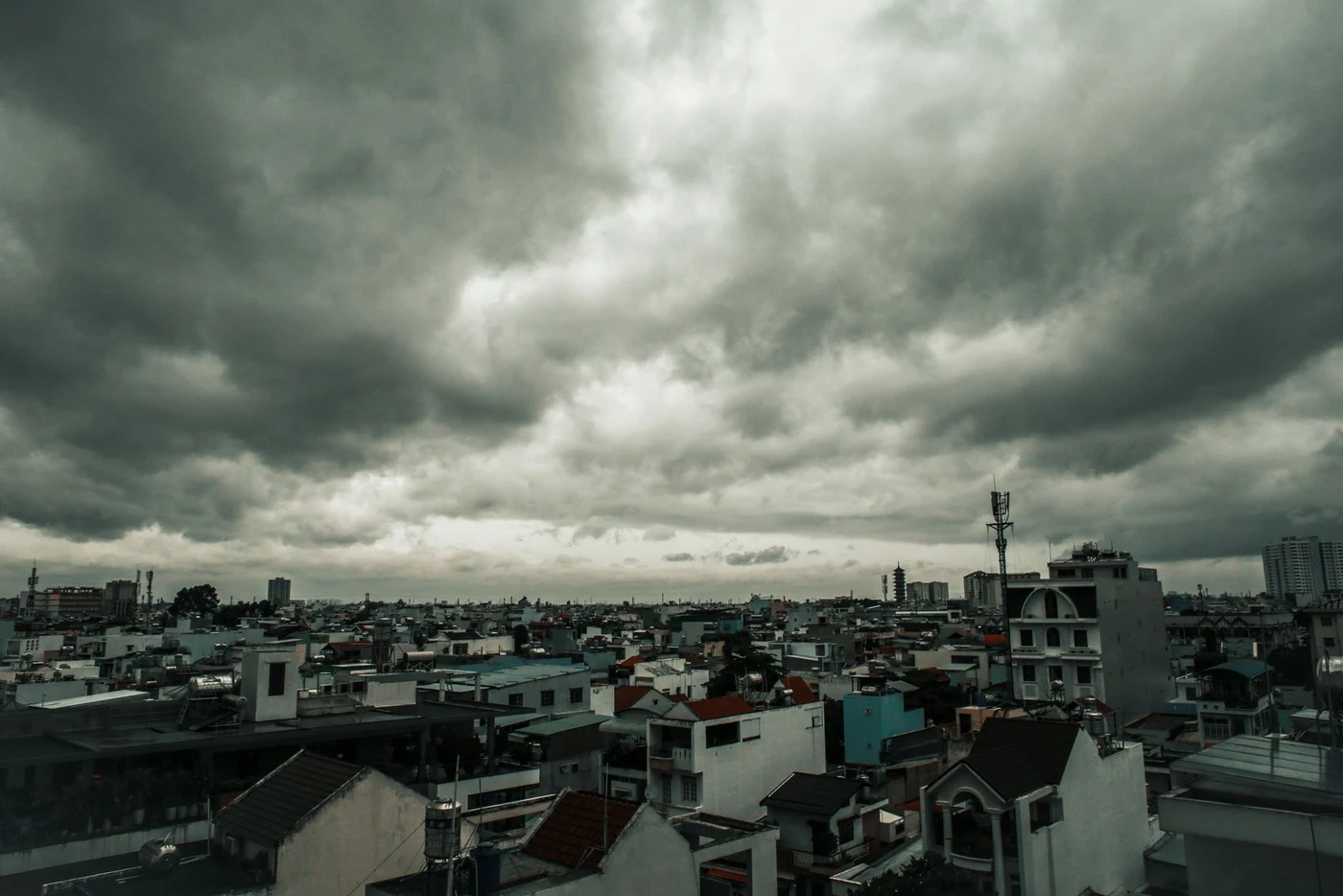 Heavy grey clouds over the roofs of a Vietnamese city