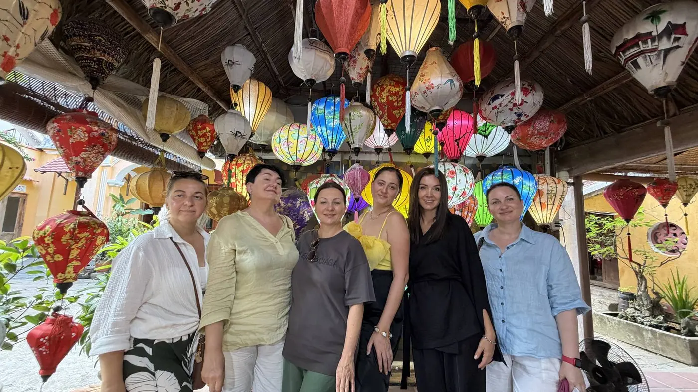 Group of travelers among silk lanterns in a Hoi An workshop