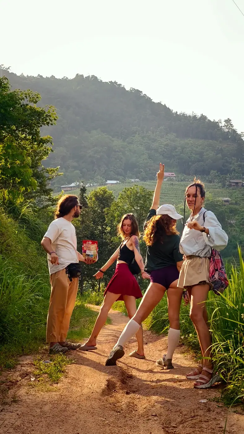 A small group of travelers with backpacks walking a dirt trail in the Vietnamese mountains