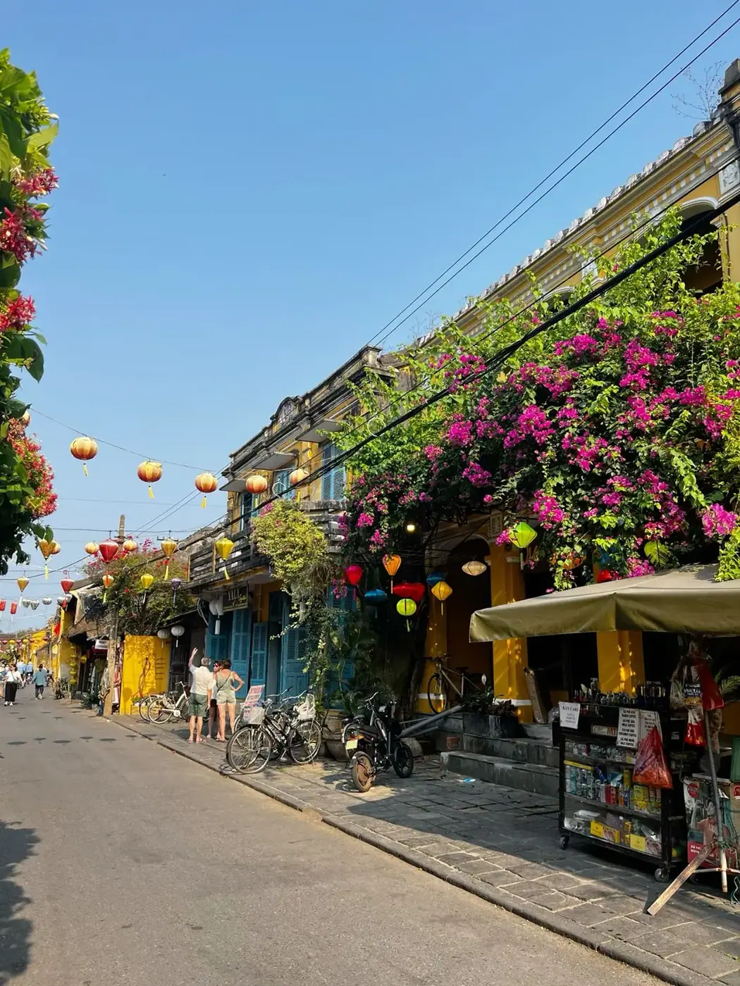 Hoi An Ancient Town street with yellow colonial buildings, lanterns and bougainvillea