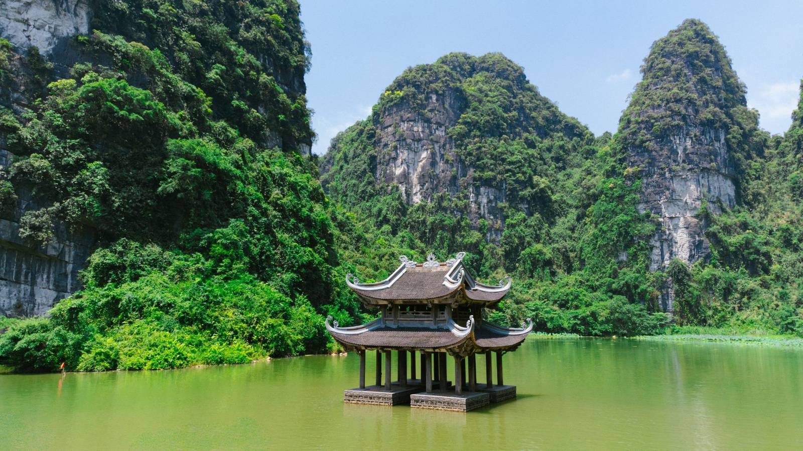 Wooden pagoda on the water surrounded by karst peaks at Trang An, Ninh Binh