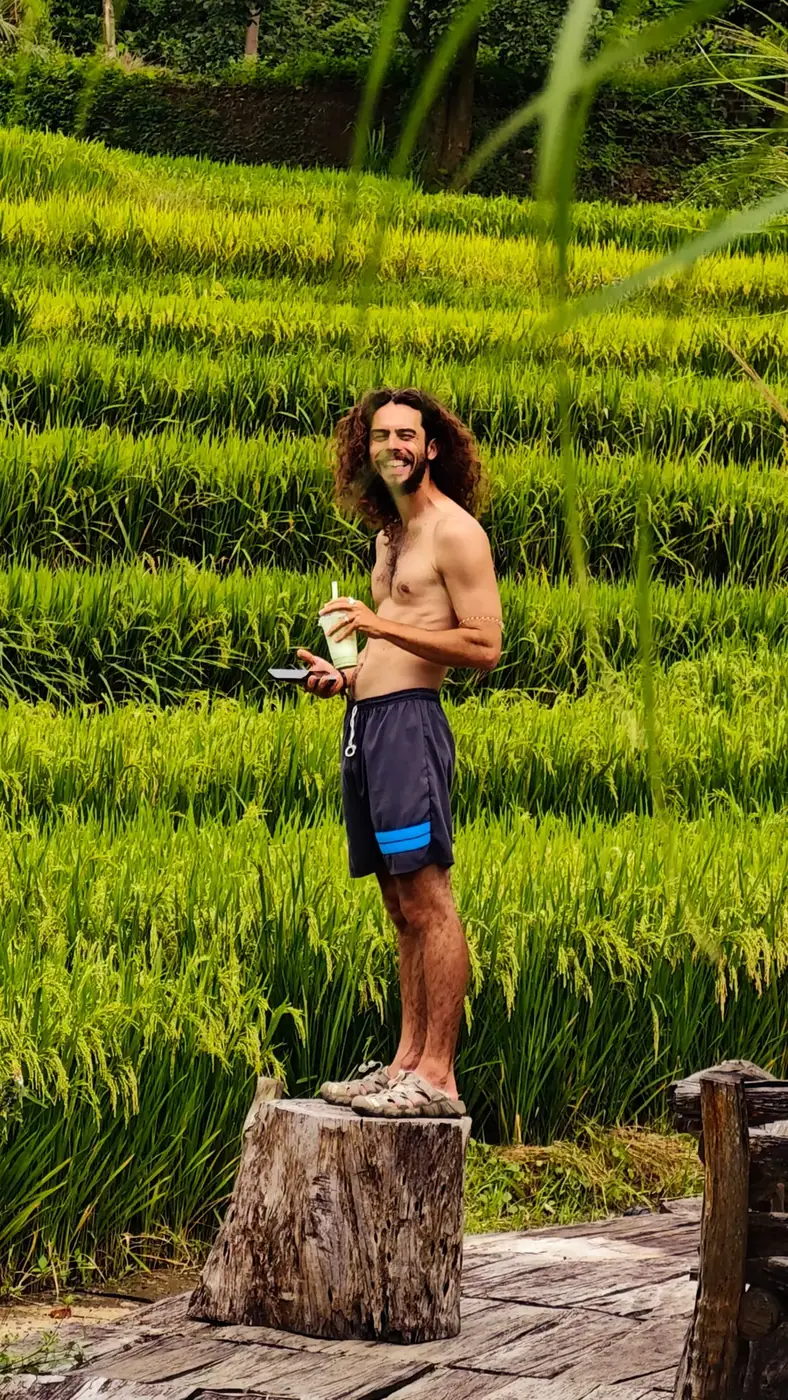 Traveler standing on a tree stump above the Moc Chau rice terraces