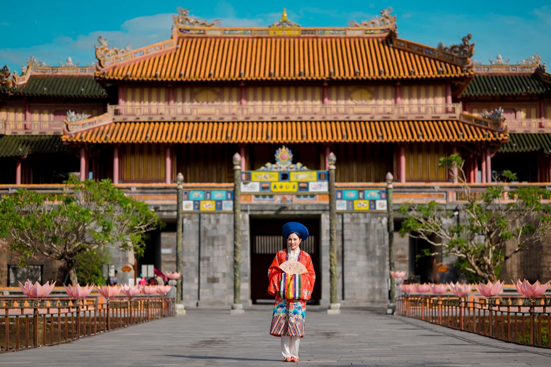 Woman in traditional Vietnamese dress at Hue Imperial City