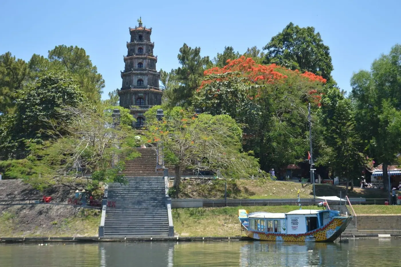 Thien Mu Pagoda tower rising above trees on the Perfume River in Hue