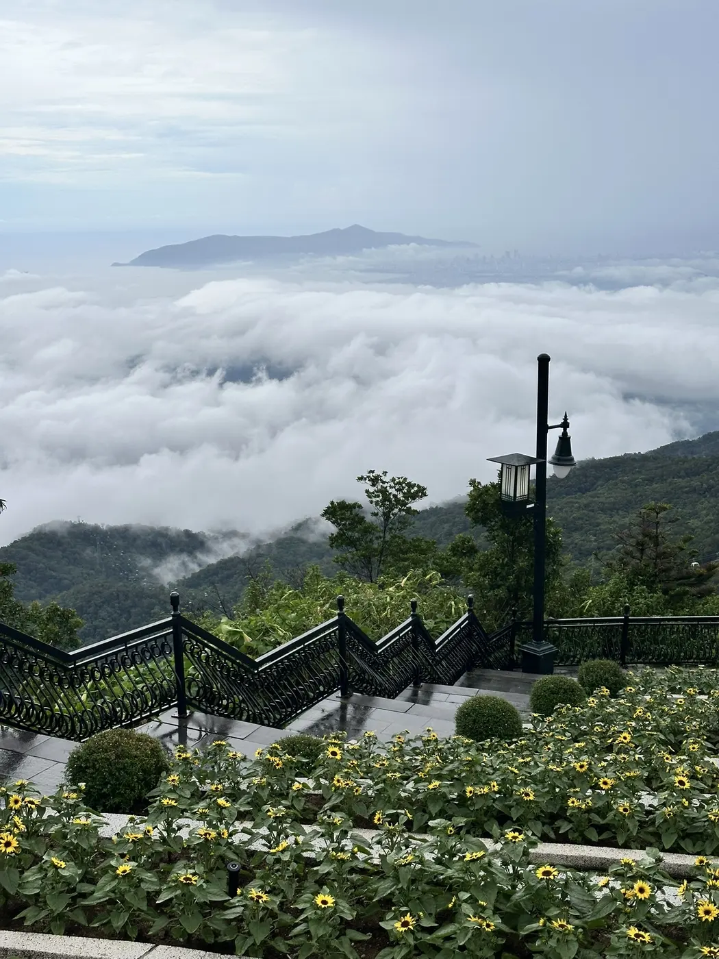 Viewing platform stairs on Ba Na mountain with a sea of clouds and the Da Nang coast