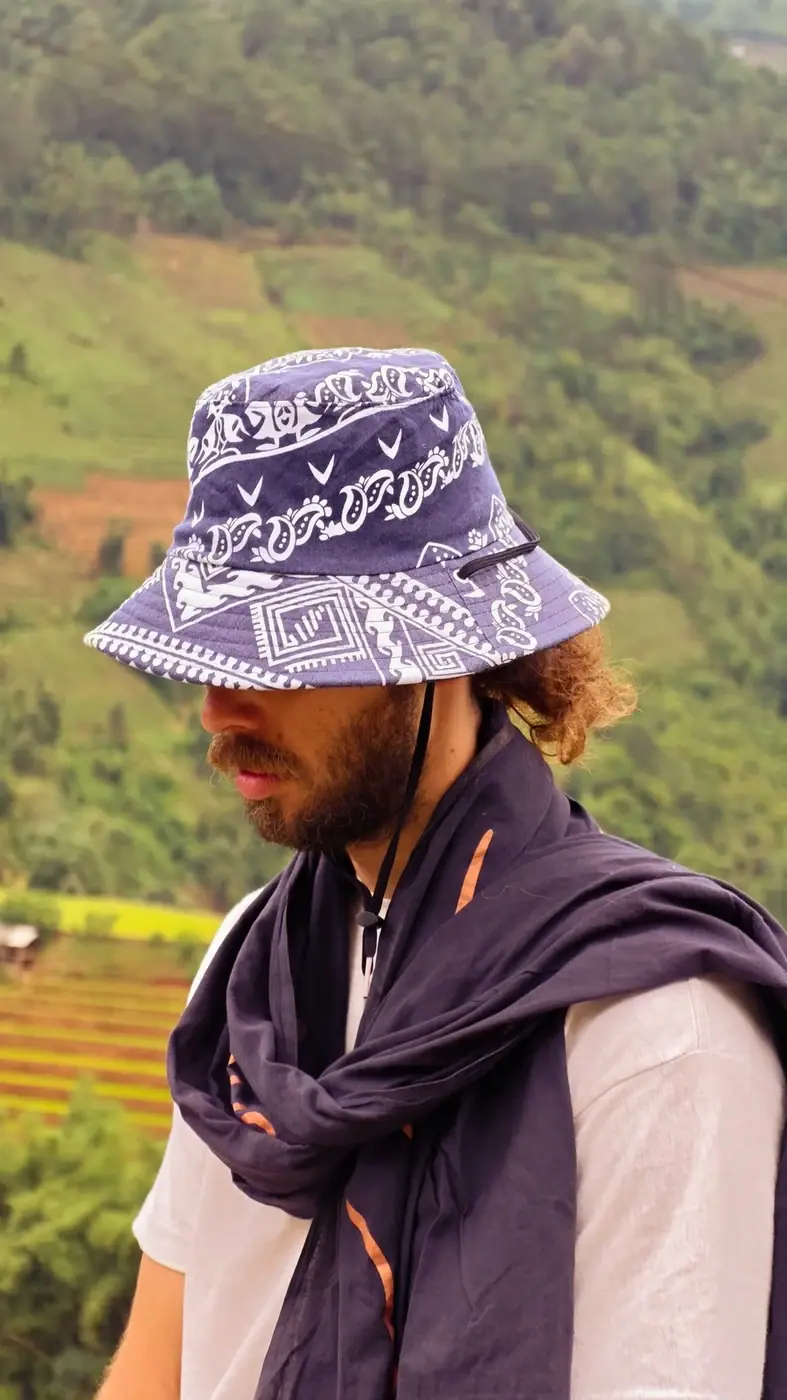Traveler in a bucket hat overlooking Vietnamese rice terraces