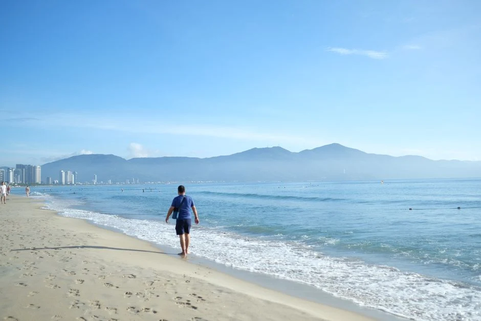 Morning walk on Da Nang beach near Marble Mountains with mountains on the horizon