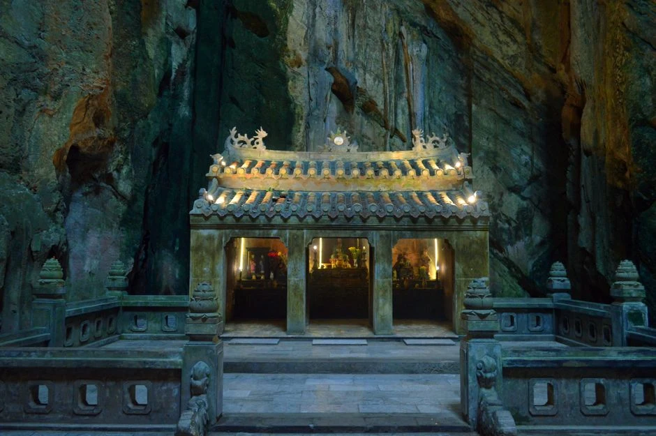 Cave temple with lit altars inside Marble Mountains in Da Nang