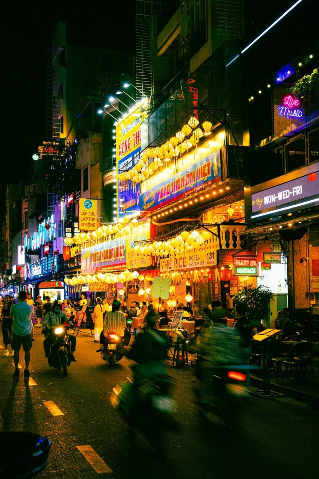 Bui Vien street at night in Ho Chi Minh City with neon signs and motorbikes