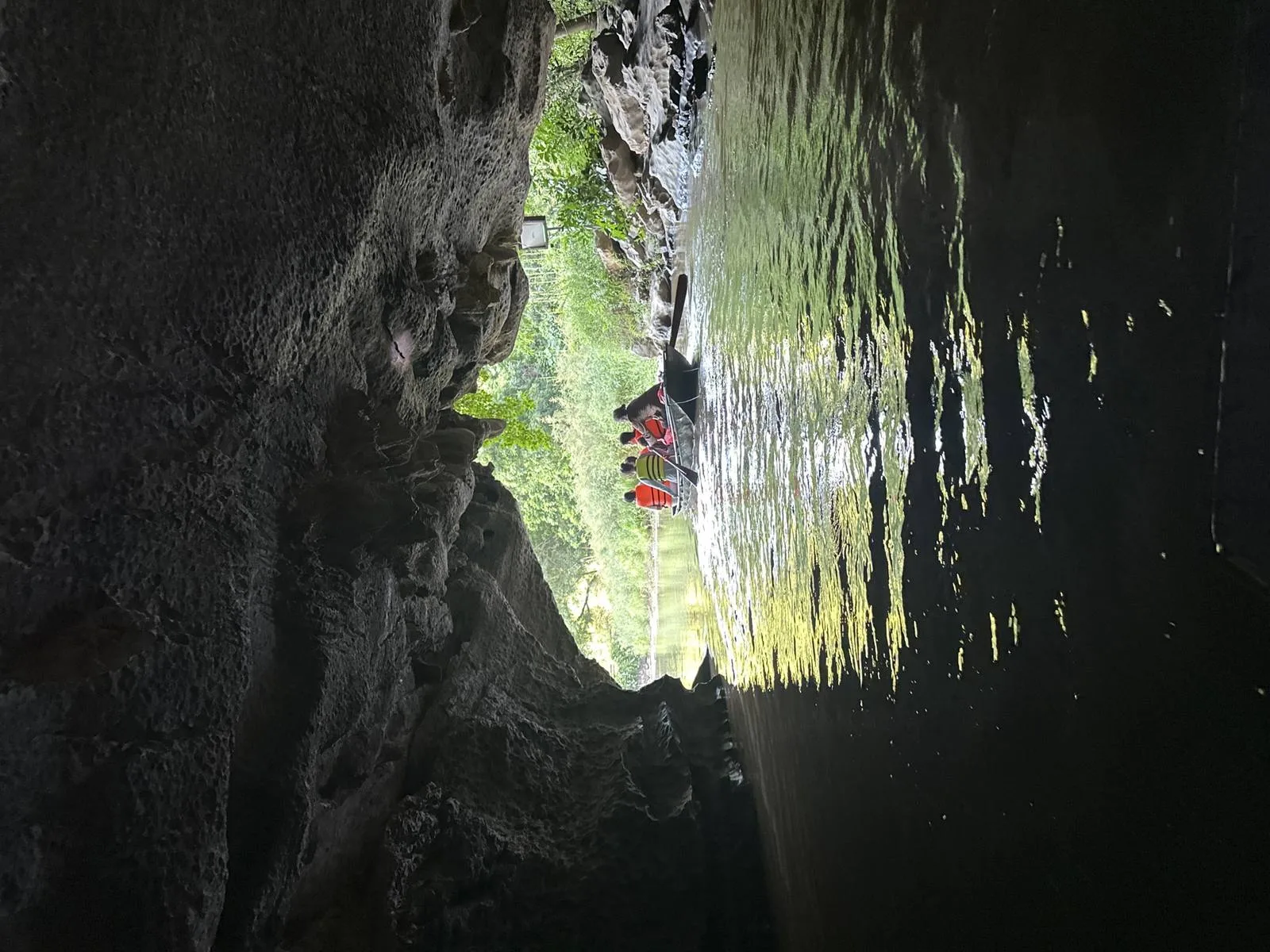 Tourist boat emerging from a cave tunnel on a river in Ninh Binh, Vietnam
