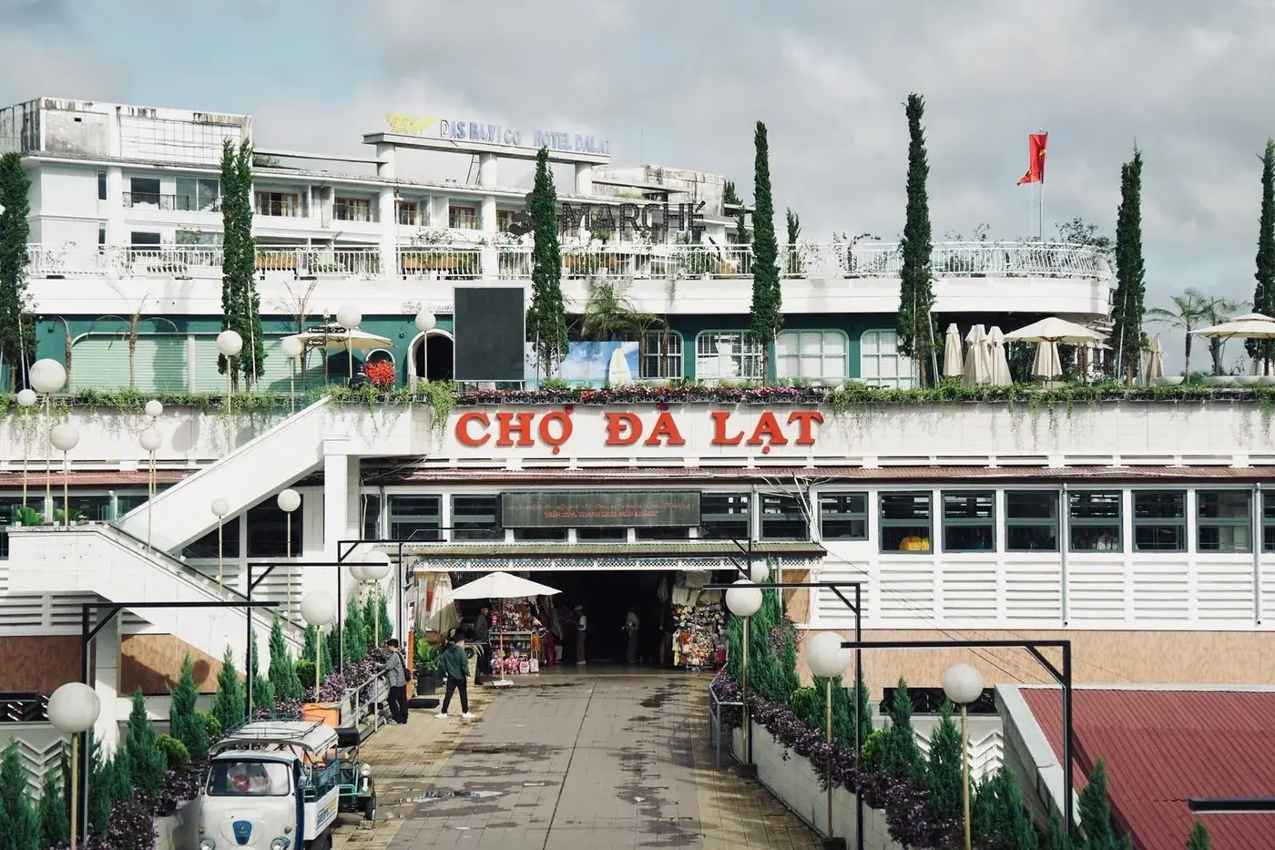 Entrance to Cho Da Lat market with vendors and signage