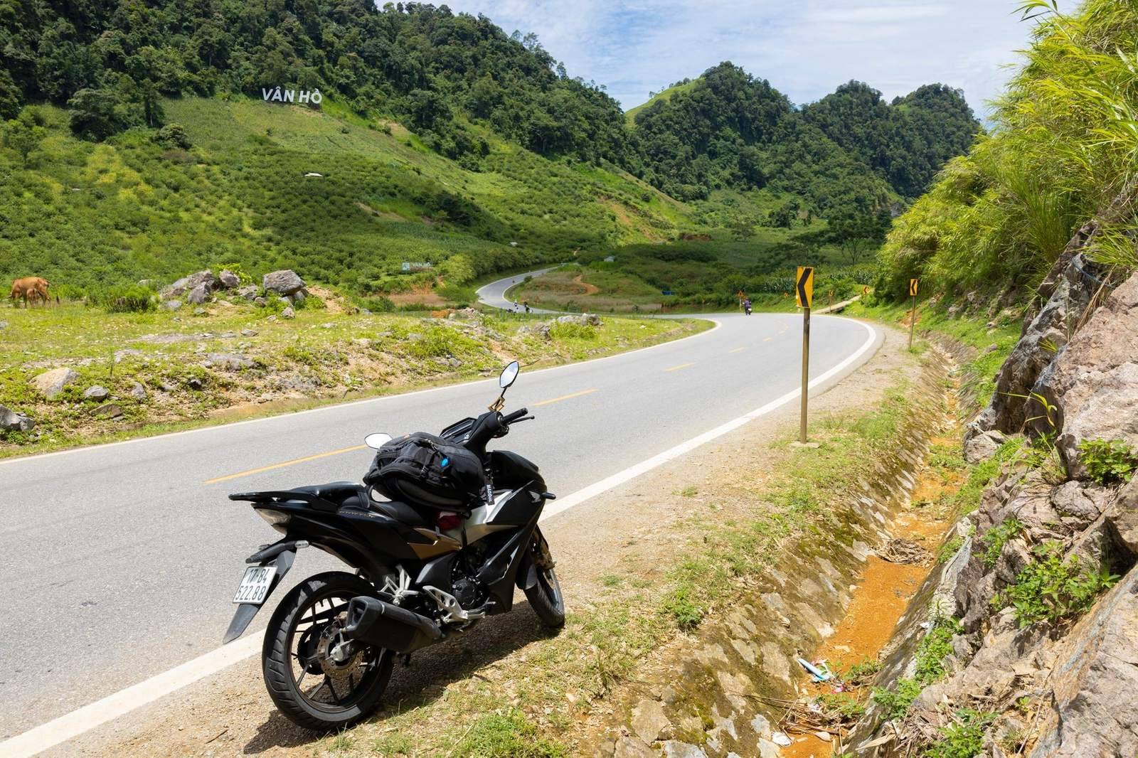 Motorbike parked on a winding mountain pass road in Vietnam