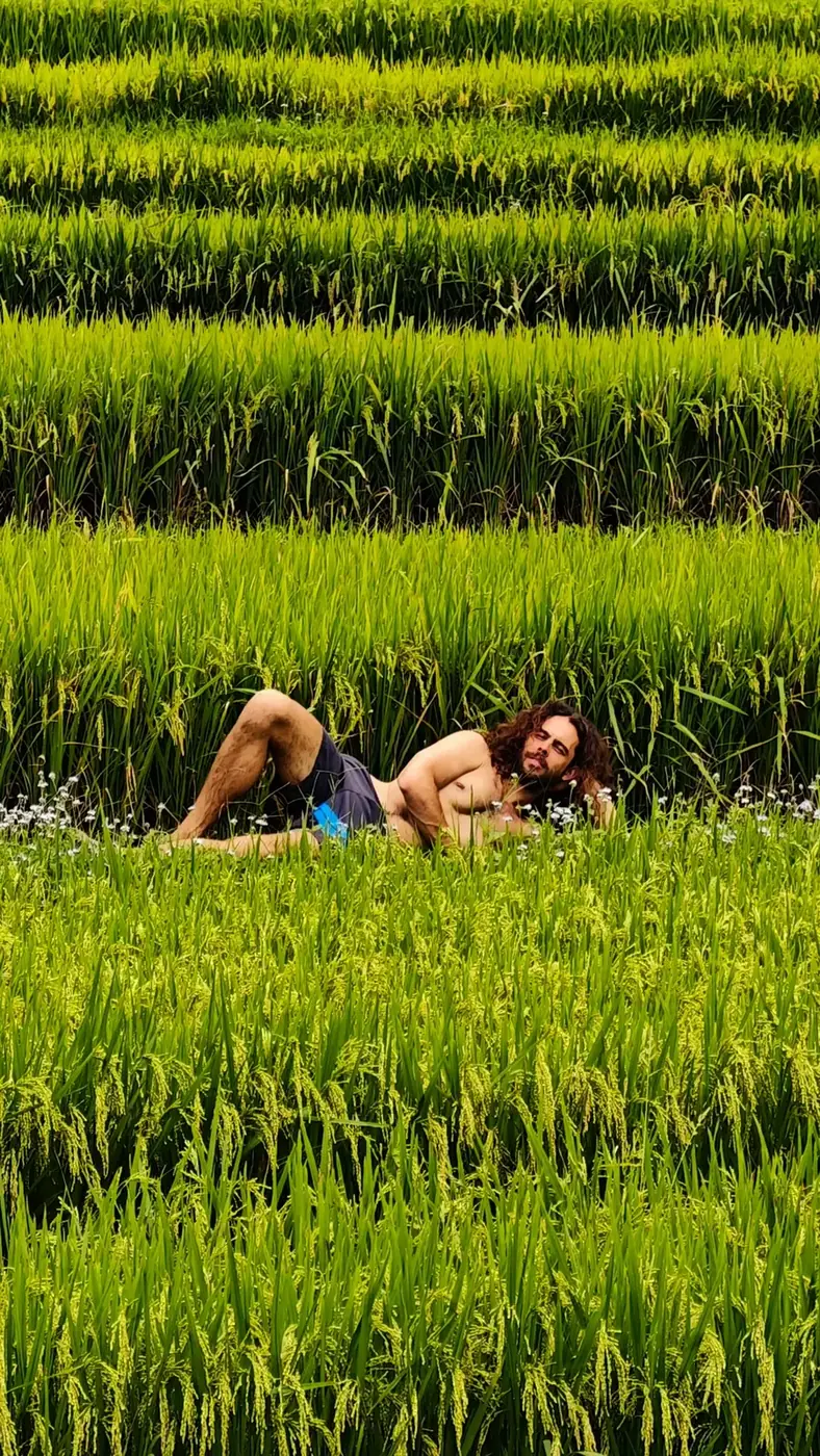 Traveler laughing while lying in a rice field in Moc Chau, Vietnam