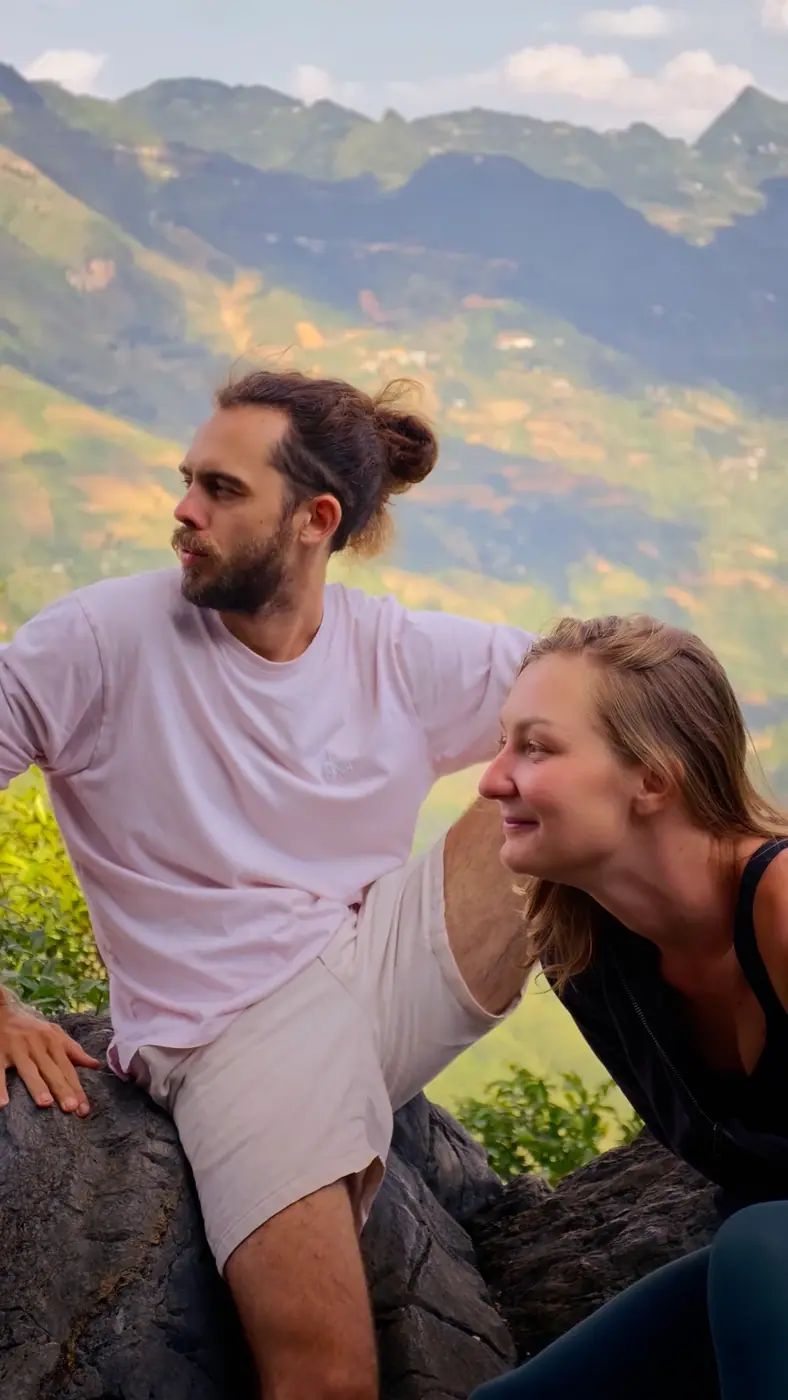Couple standing on a rock viewpoint above rice terraces in Vietnam