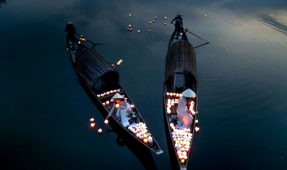 Colorful lantern boats docked on Hoi An’s river at night during festival season