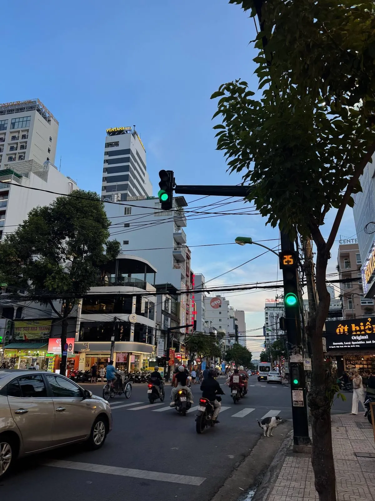 Evening traffic on a Nha Trang street with motorbikes and a traffic light