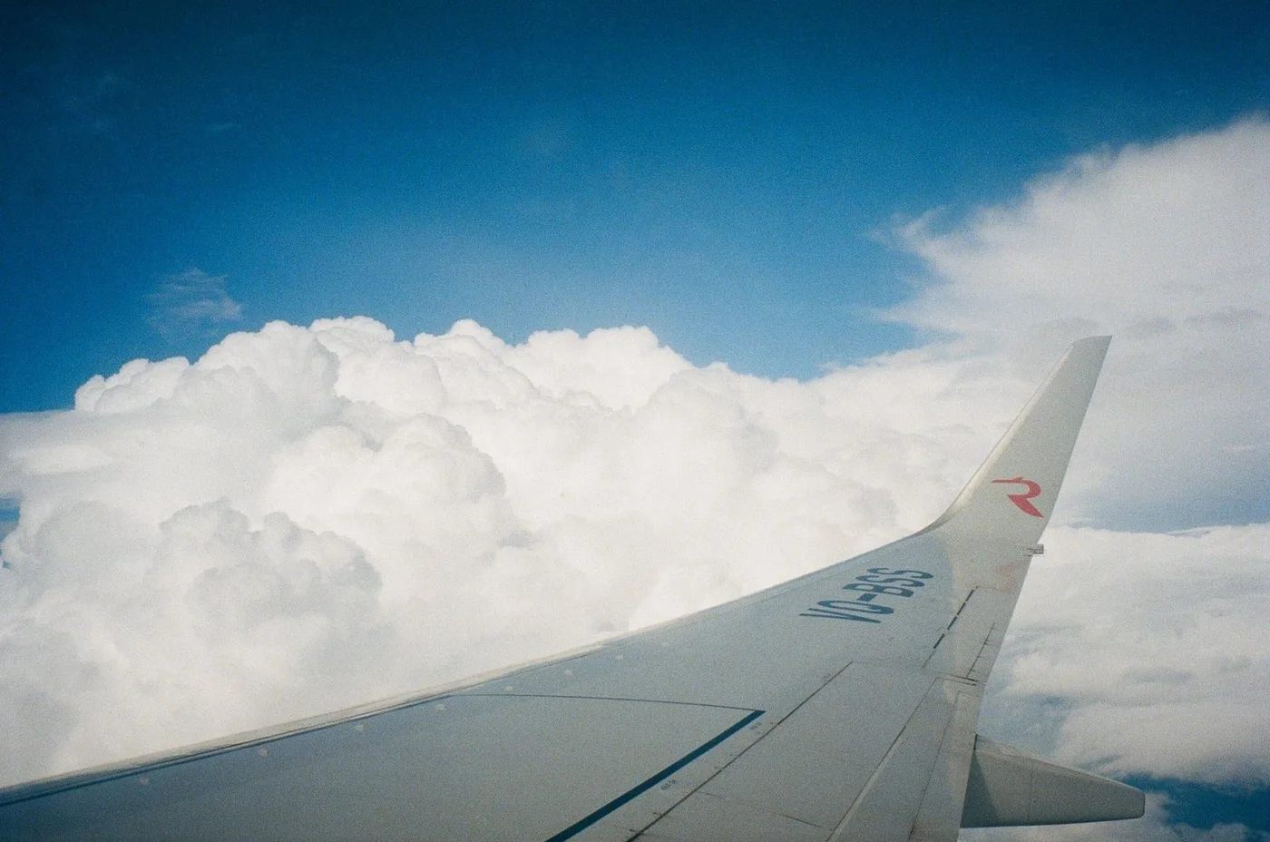 Airplane wing above white clouds during a flight