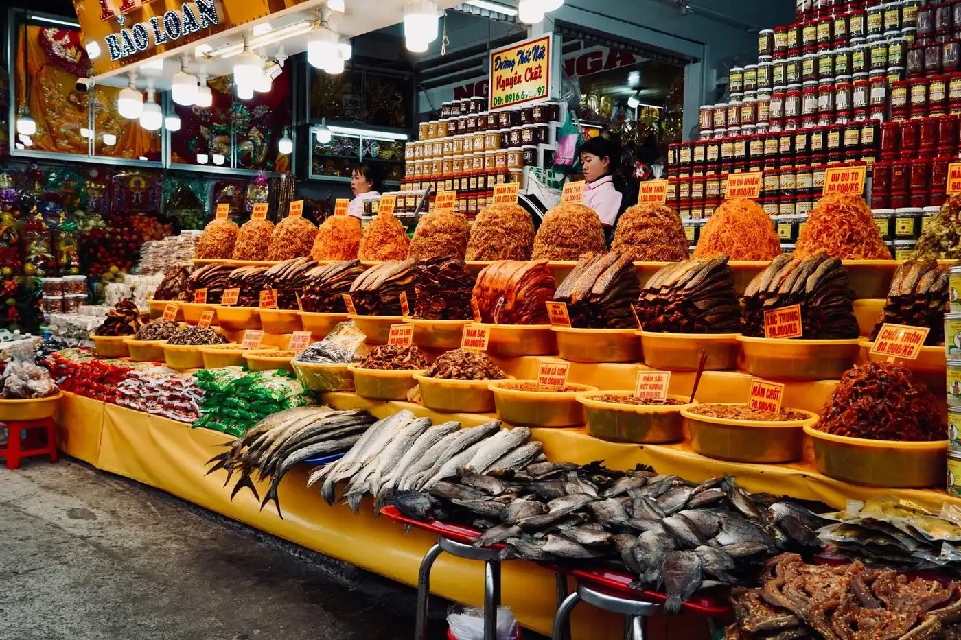 Stall of dried fish and shrimp piled in bowls at a Vietnamese market