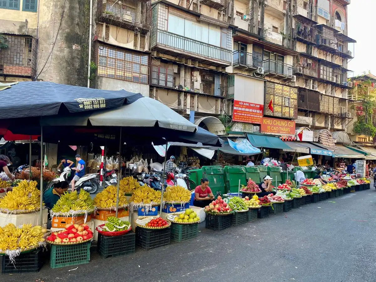 Rows of fruit baskets lined up along a Vietnamese market street