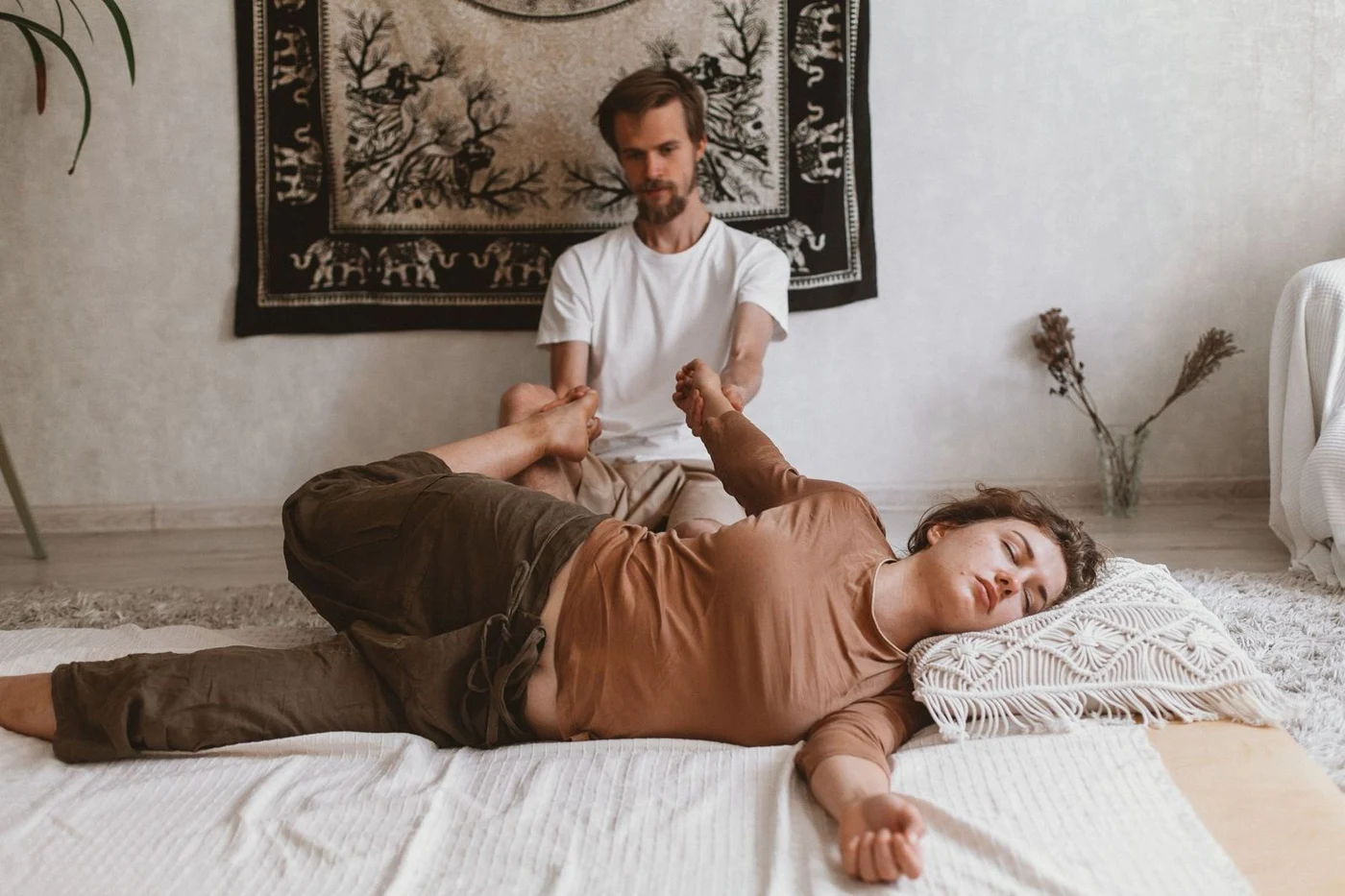 Thai massage with leg stretching on a mat