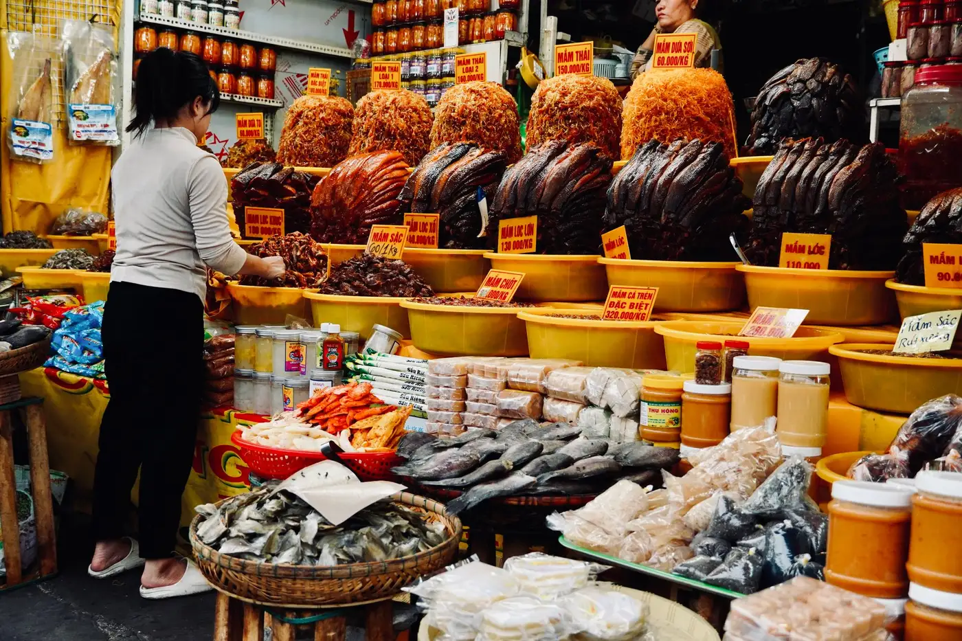 Stall with baskets of dried fish and fermented fish sauces with price tags